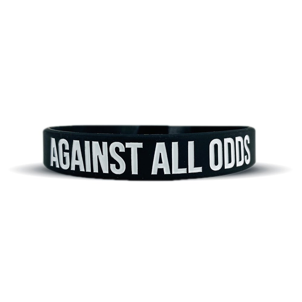 Black wristband with 'Against All Odds' text on a white background