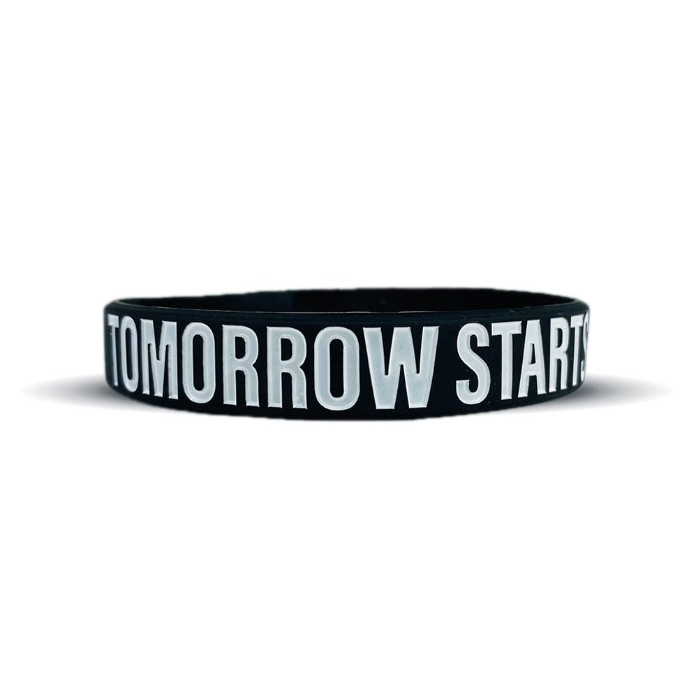 Black wristband with 'TOMORROW STARTS' text on a white background