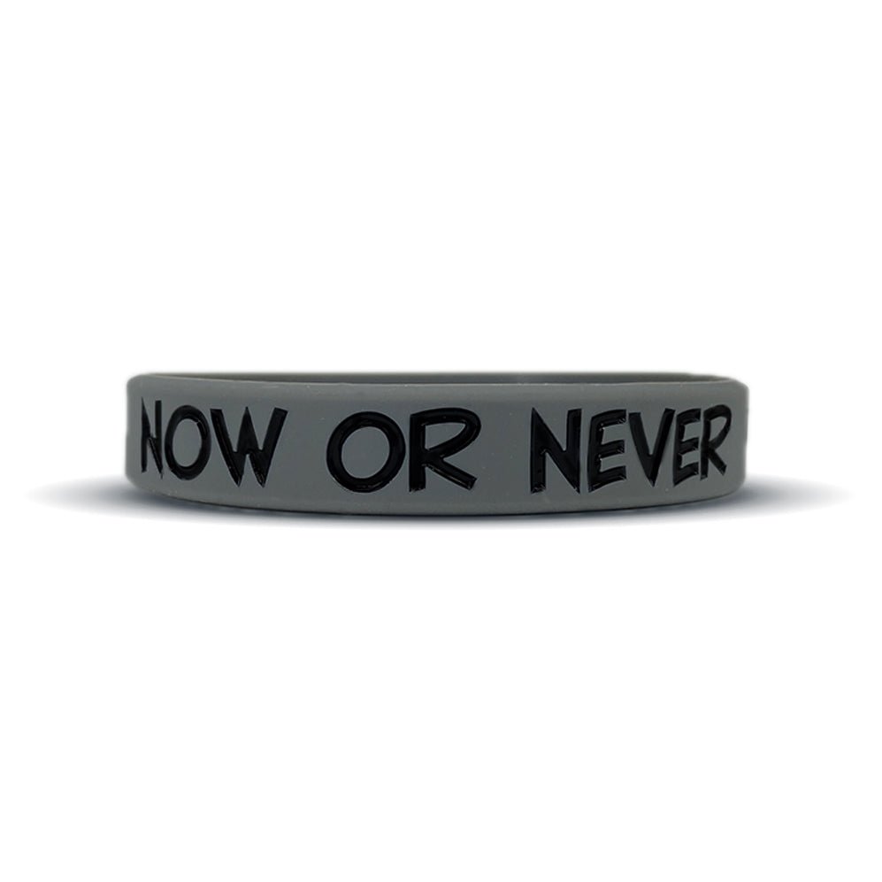 Gray wristband with 'NOW OR NEVER' text on a white background
