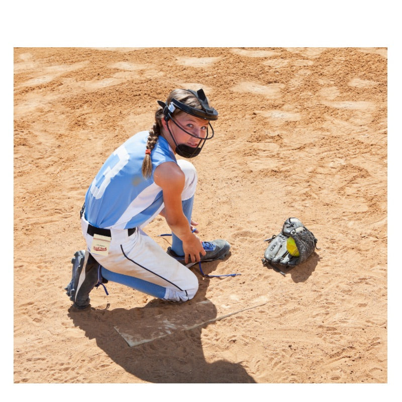 Person in a blue and white sports uniform on a dirt field