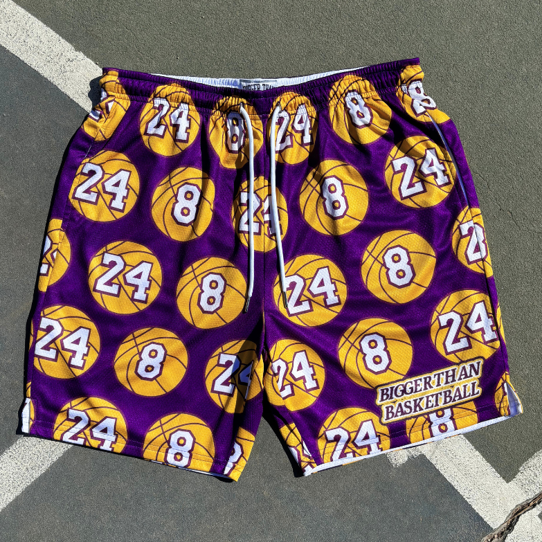 Kobe Numbers Purple shorts with yellow basketballs and numbers on a gray surface