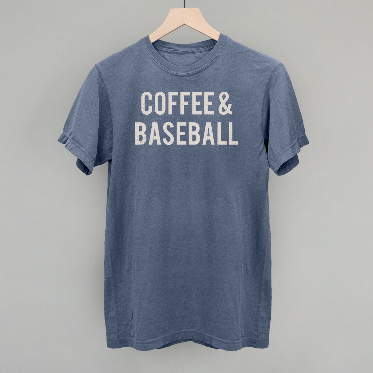 Collection of Blue comfort colors t-shirt with 'COFFEE & BASEBALL' text on a hanger against a gray background in a gallery layout