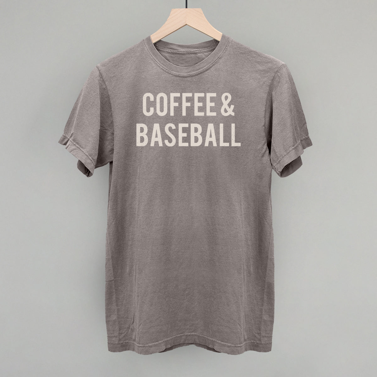 Collection of Gray comfort colors t-shirt with 'COFFEE & BASEBALL' text on a hanger against a gray background in a gallery layout