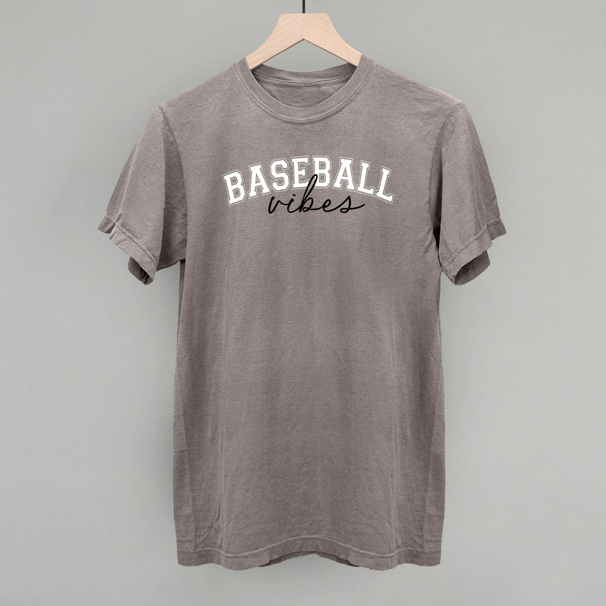 Collection of Gray t-shirt with 'Baseball vibes' text on a hanger against a gray background in a gallery layout