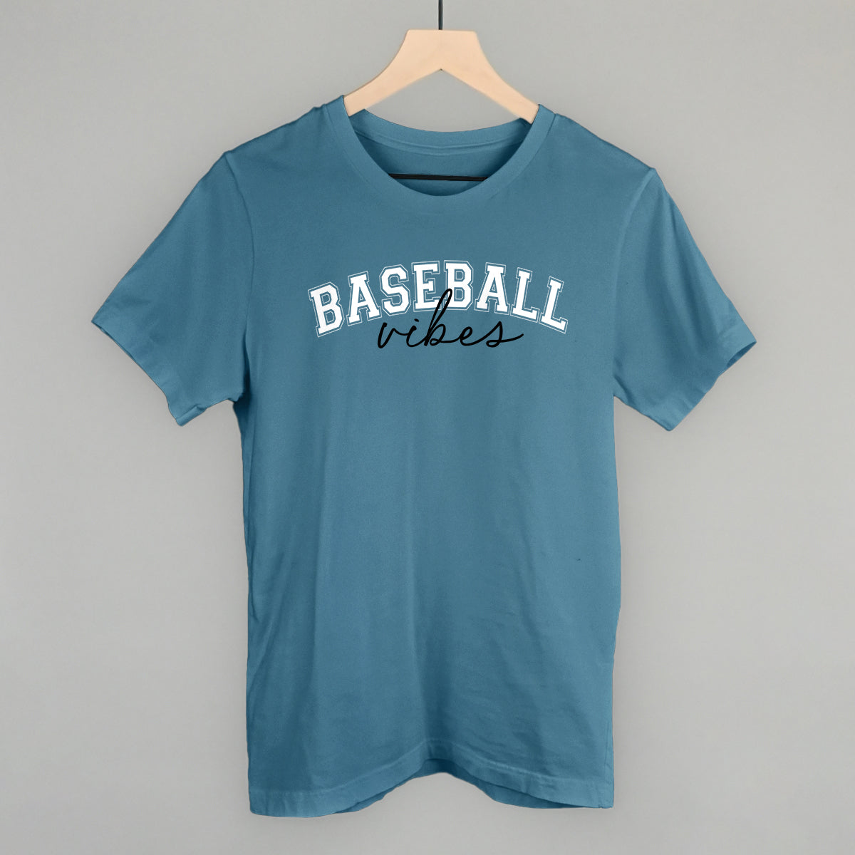 Blue t-shirt with 'BASEBALL vibes' text on a hanger against a gray background