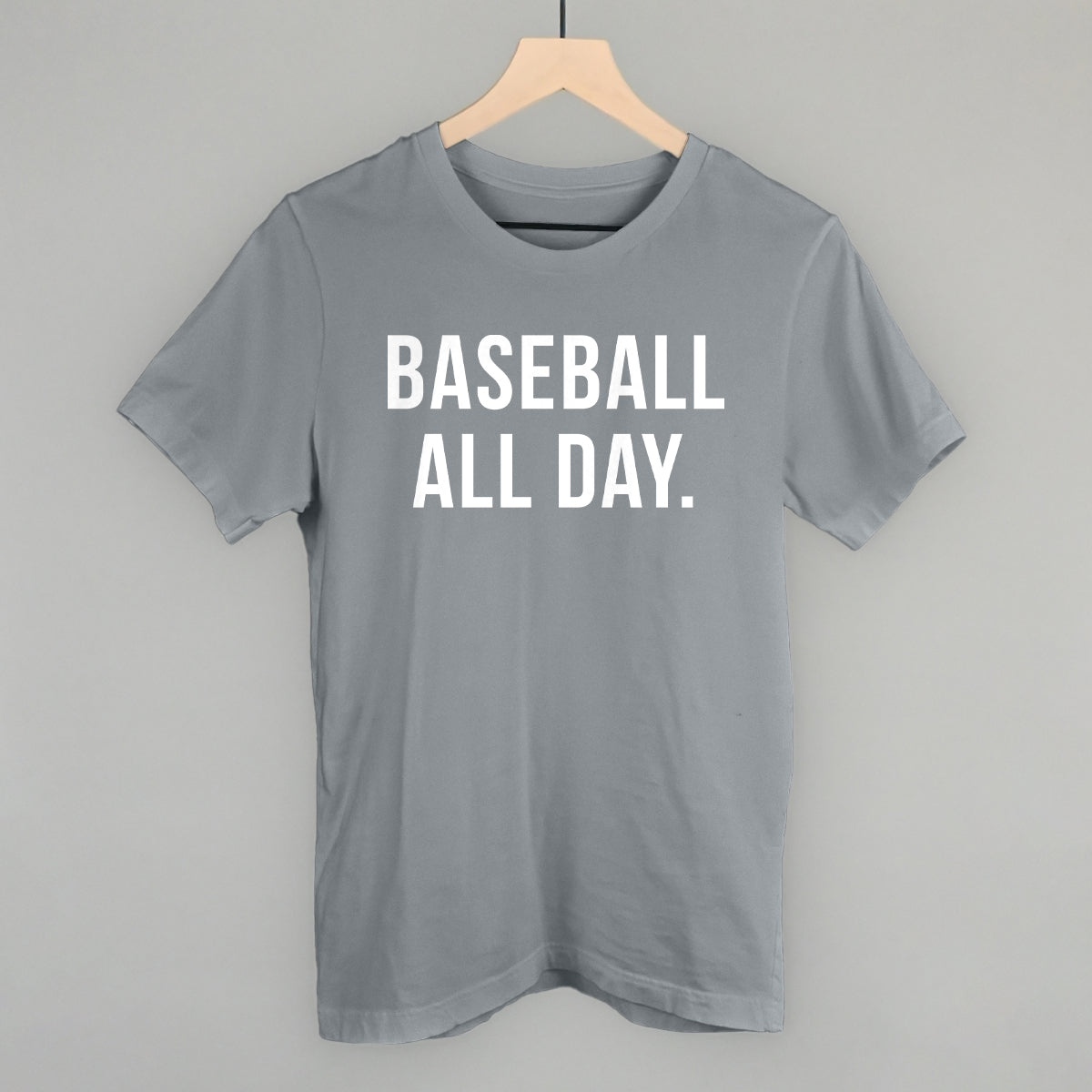 Gray t-shirt with 'BASEBALL ALL DAY.' text on a hanger against a gray background