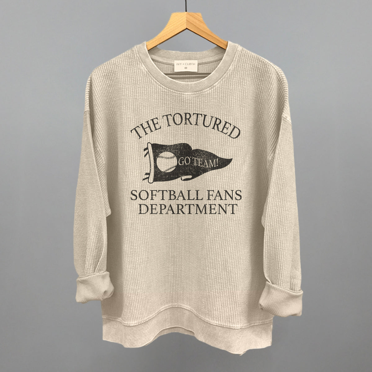 Beige sweatshirt with graphic design that says the tortured Softball fans department 