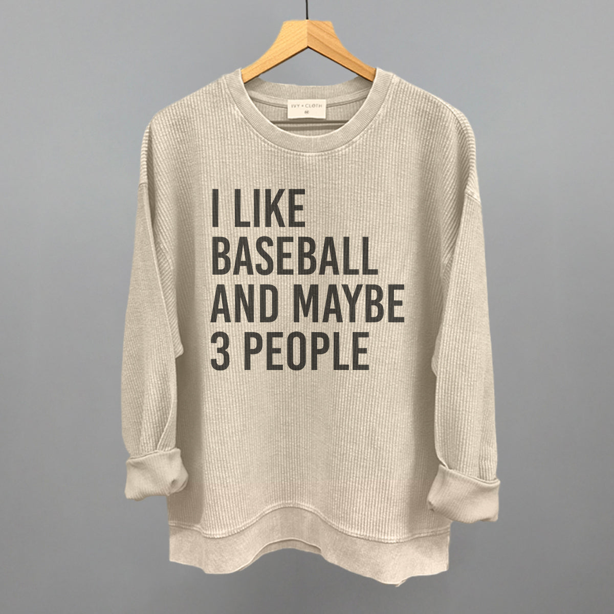 Collection of Moonbeam sweatshirt with text 'I LIKE BASEBALL AND MAYBE 3 PEOPLE' on a hanger against a gray background in a gallery layout