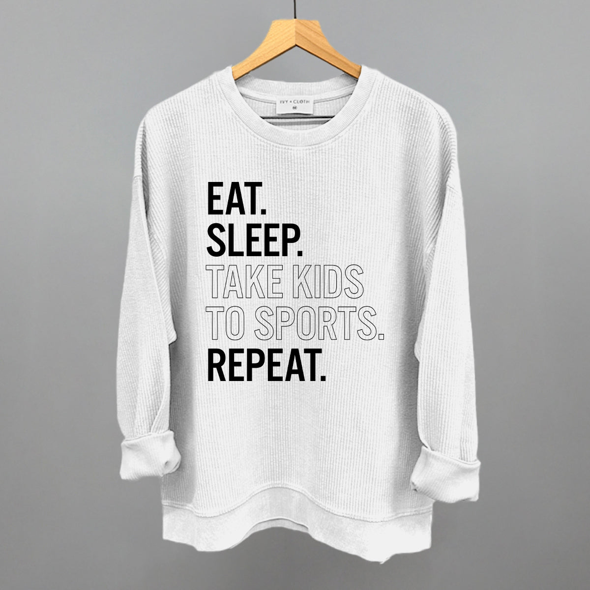Collection of White corded crew sweatshirt with text on a hanger against a gray background in a gallery layout