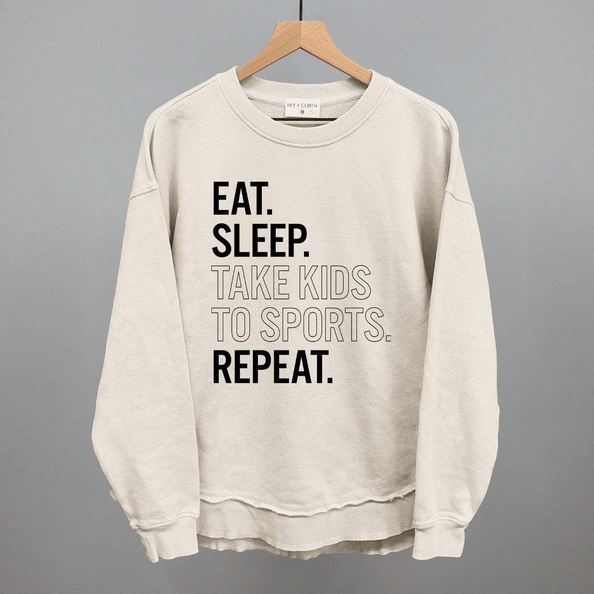 Collection of tapioca comfort colors sweatshirt with text on a hanger against a gray background in a gallery layout
