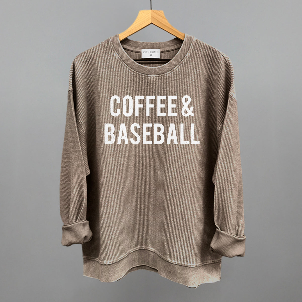 Collection of Brown corded crew sweatshirt with 'COFFEE & BASEBALL' text on a hanger against a gray background in a gallery layout