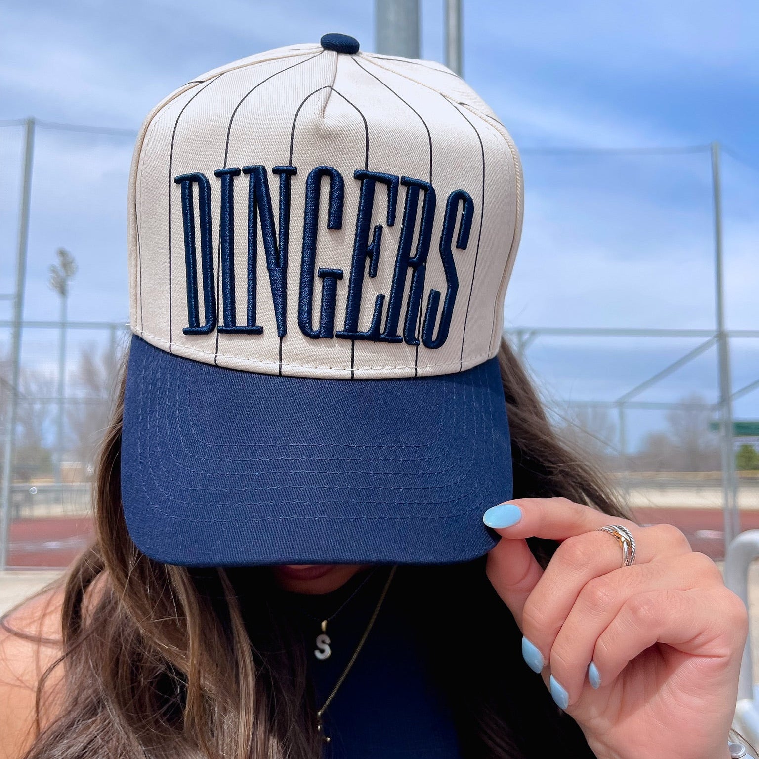 Collection of Person wearing a cap with 'DINGERS' text outdoors in a gallery layout