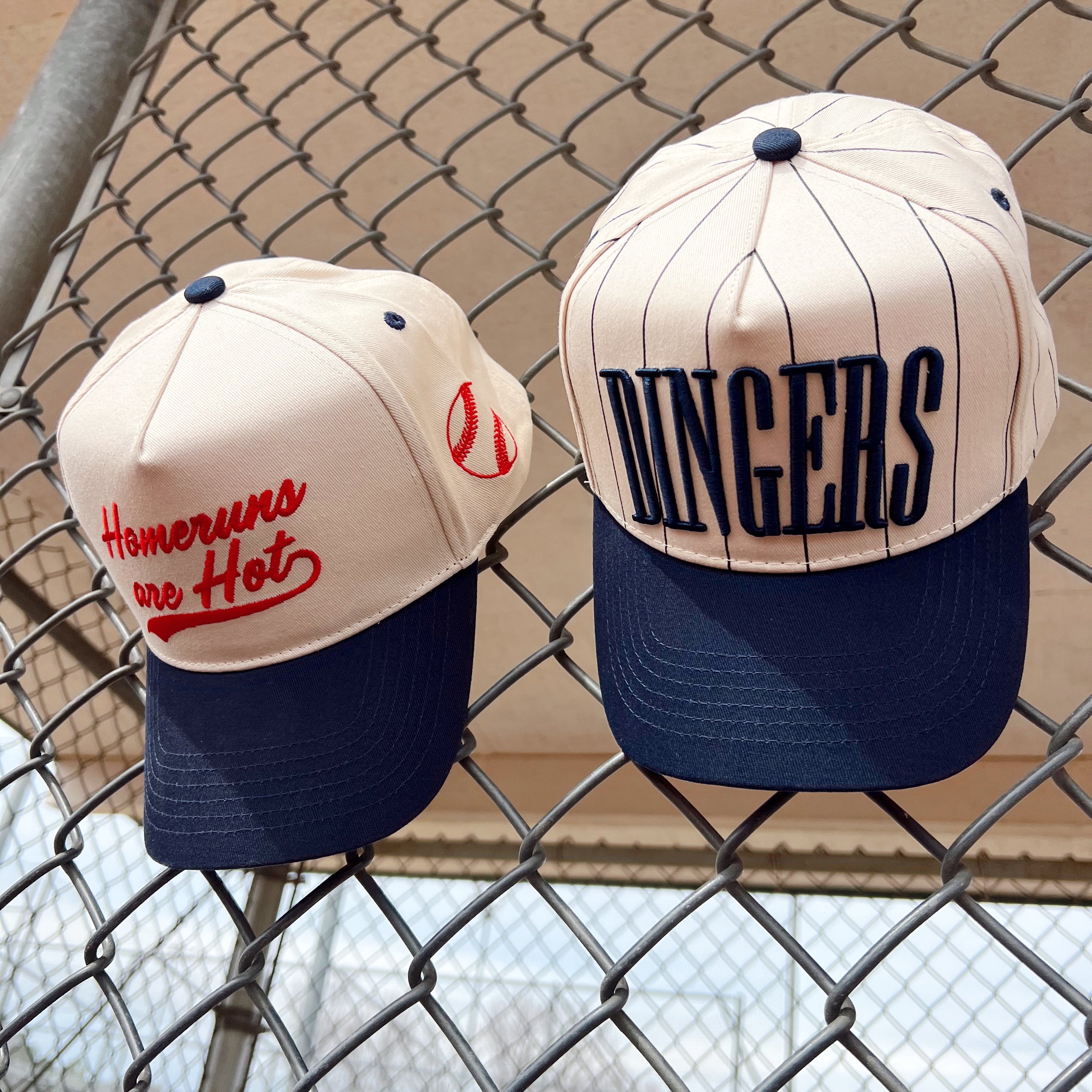Collection of Two baseball caps with text on a chain-link fence background in a gallery layout