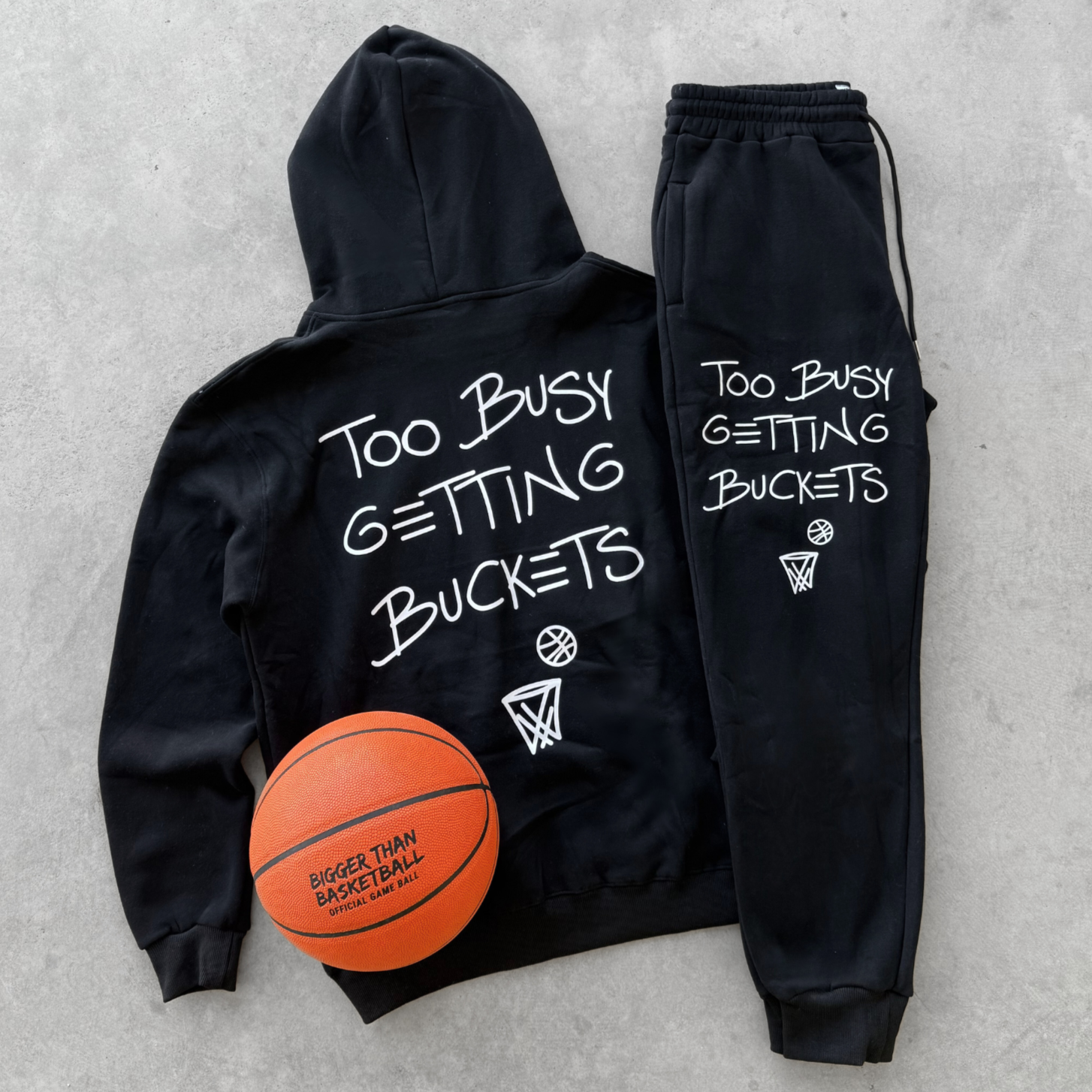 Collection of Black hoodie and jogger set with basketball-themed text on a gray background in a gallery layout
