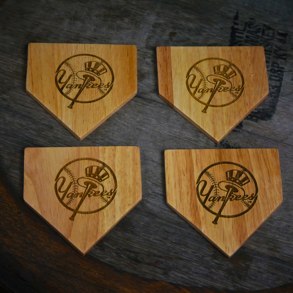 Collection of Four wooden home plate coasters with Yankees logo on a dark surface in a gallery layout