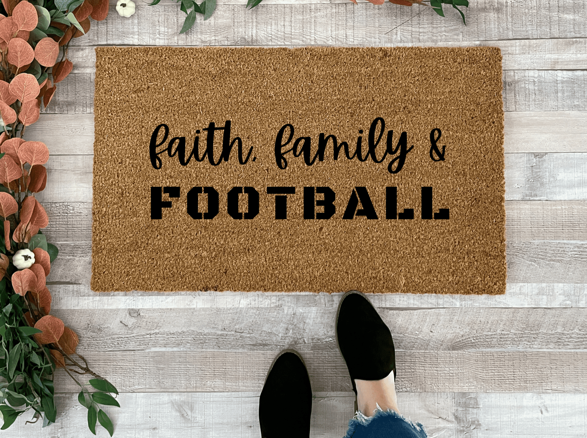 Doormat with 'Faith, Family & Football' text on a wooden floor.