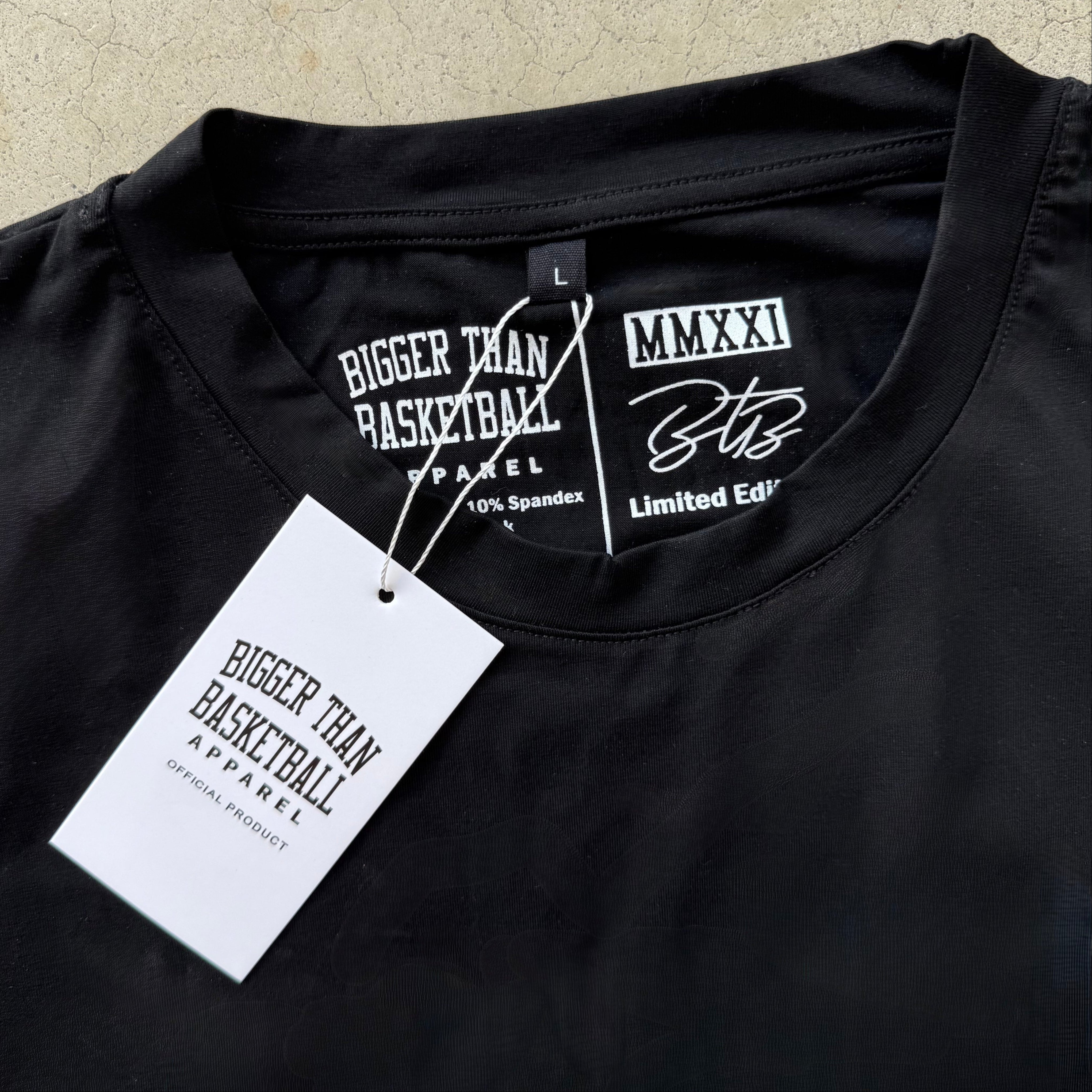 Collection of Black garment with 'Bigger Than Basketball Apparel' label and tag on a textured beige background in a gallery layout