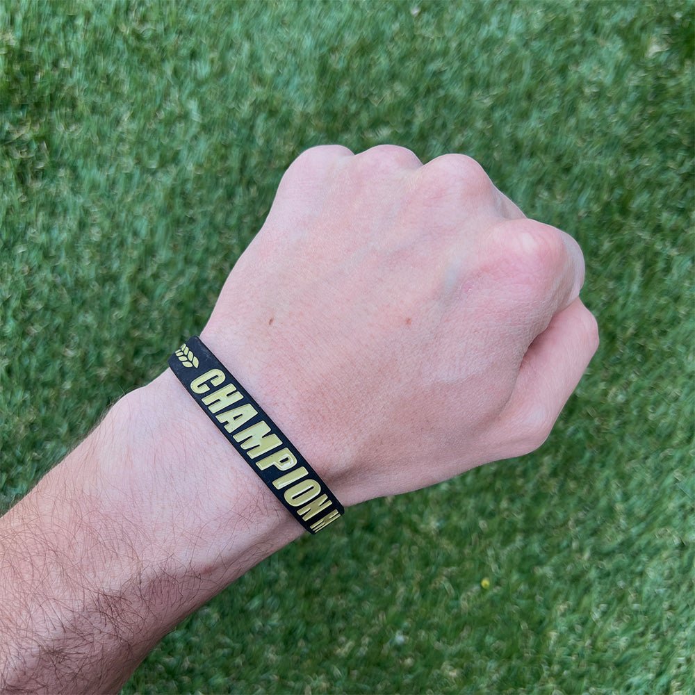 Collection of Hand wearing a wristband with 'CHAMPION' text on a grass background in a gallery layout
