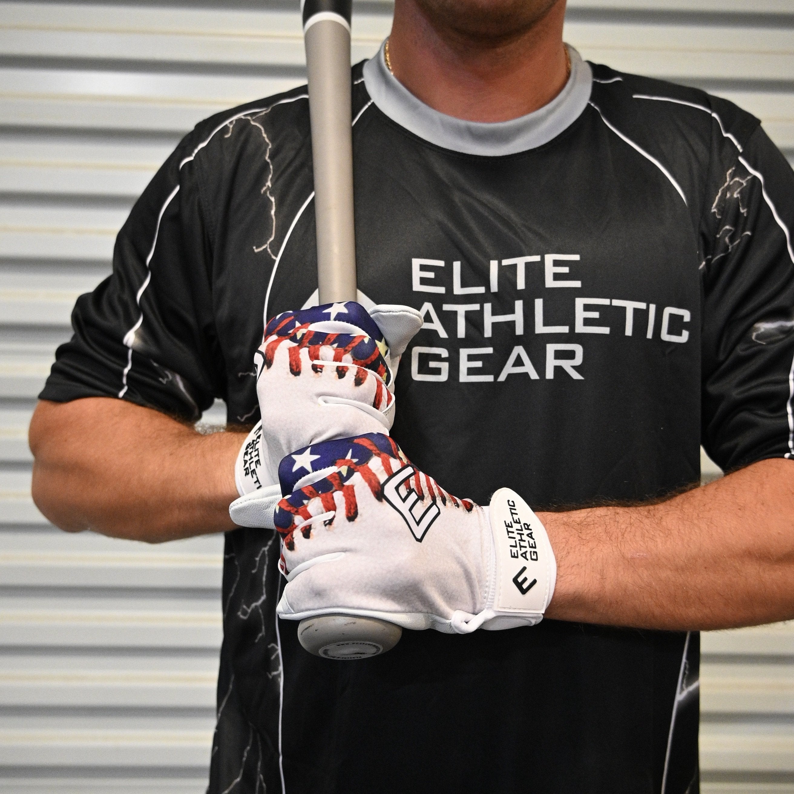 Collection of Person wearing a black 'Elite Athletic Gear' shirt and holding a baseball bat with american flag batting gloves on. in a gallery layout