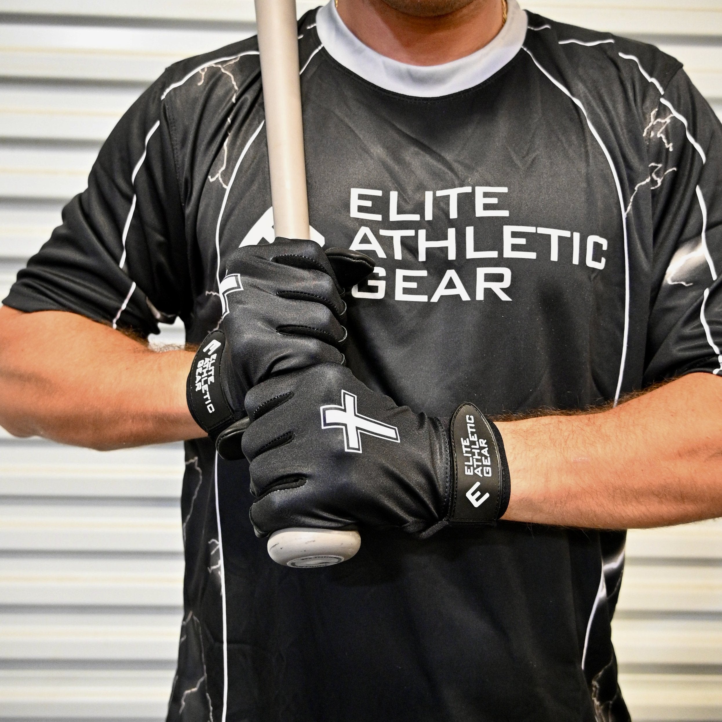 Collection of Person wearing a black 'Elite Athletic Gear' shirt and holding a baseball bat. Black batting gloves with white cross design. in a gallery layout