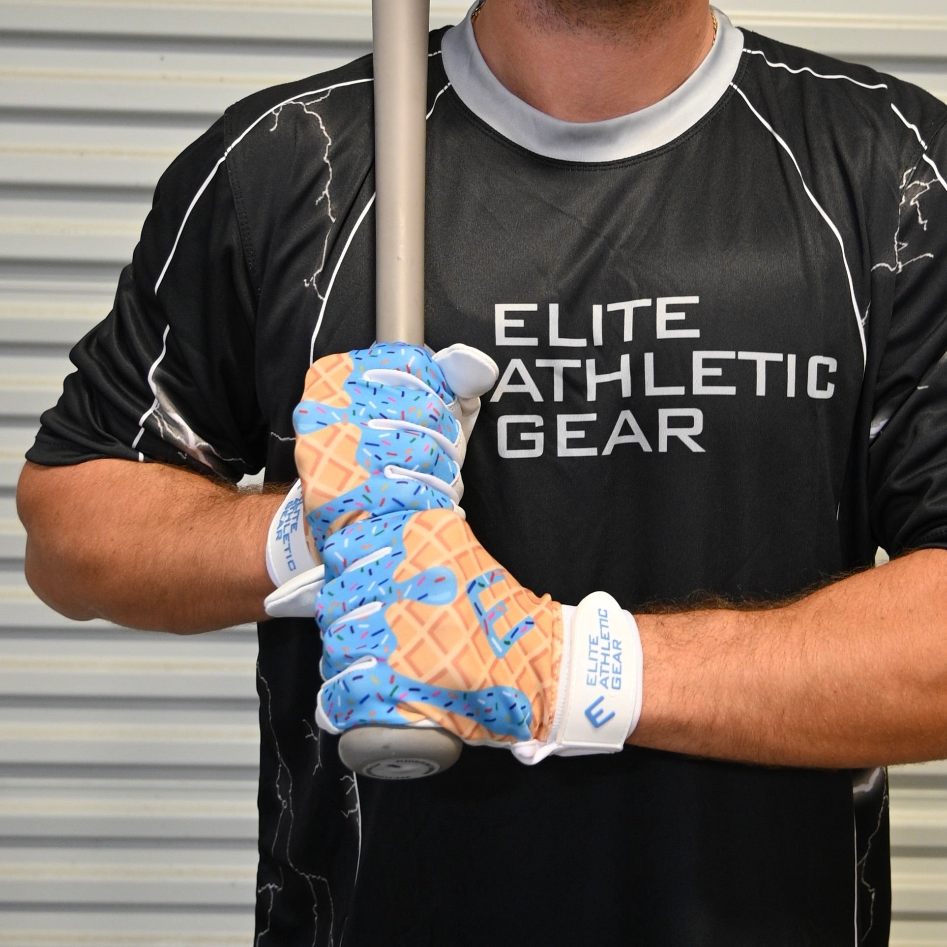 Collection of Person wearing a black 'Elite Athletic Gear' shirt holding a baseball bat with a ice cream drip batting gloves.  in a gallery layout